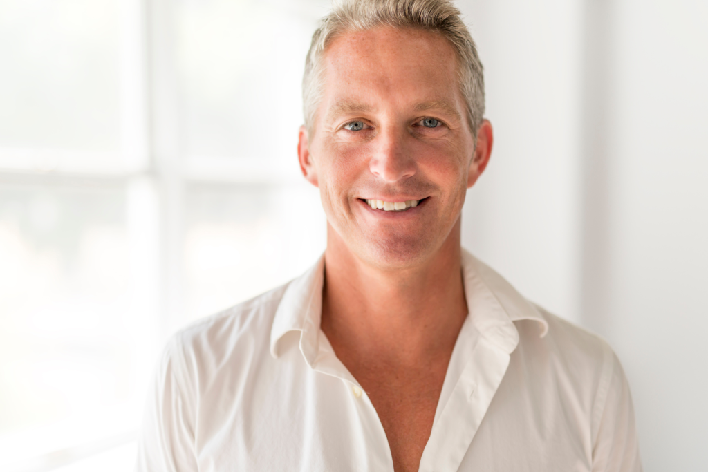 invitacion-digital-cumple-black-and-gold-fotografia-hombre-rubio-con-camisa-blanca-fondo-de-ventana-blanco