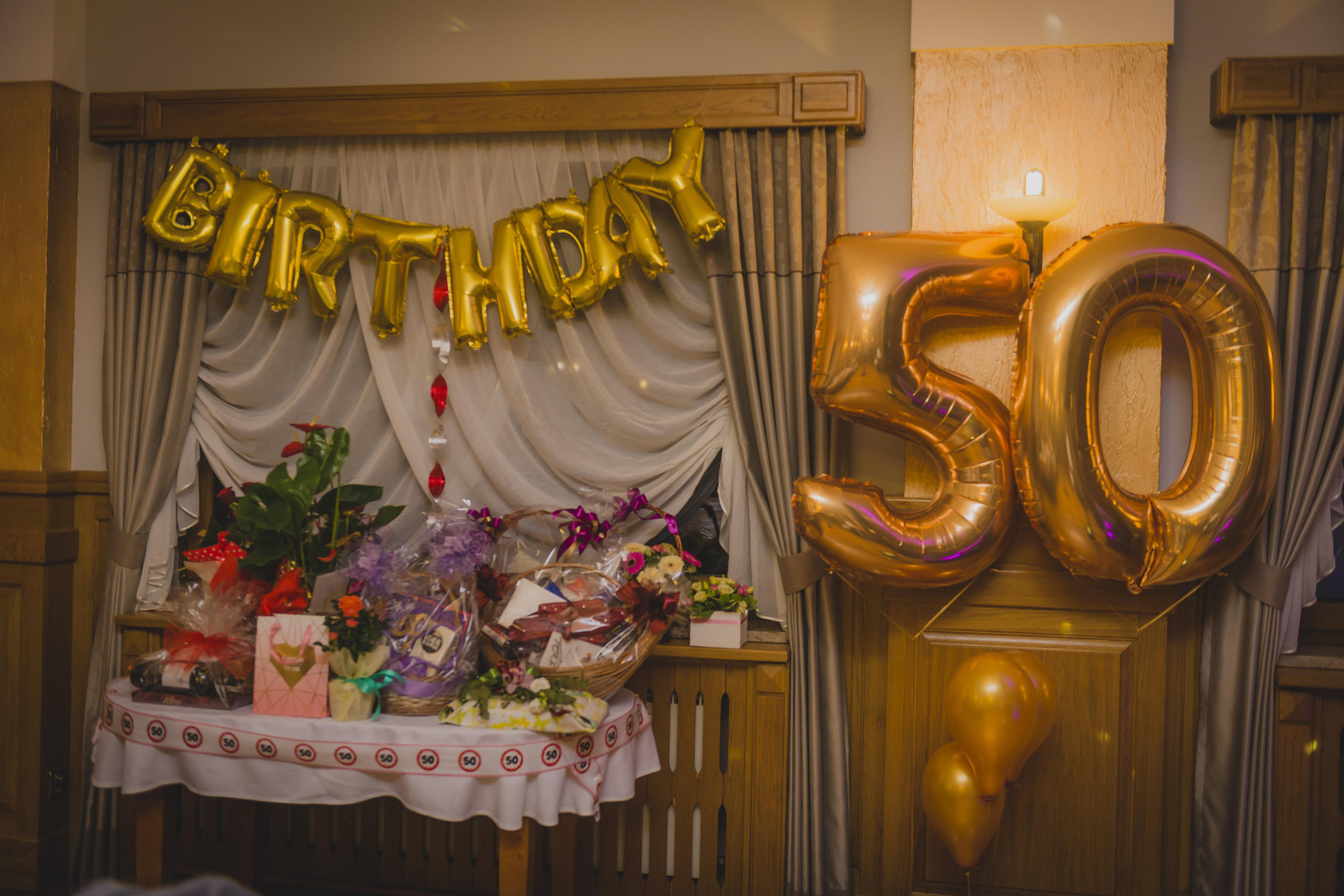 invitacion-digital-cumple-50-anos-fotografia-mesa-de-regalos-con-globos-dorados-numero-50